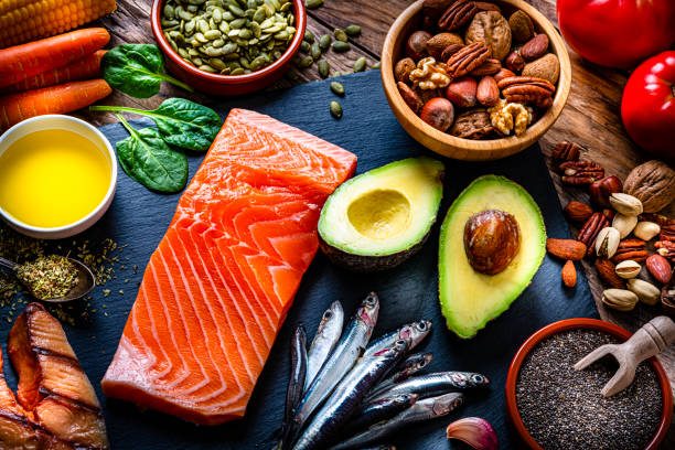 Food with high content of Omega-3 fats Healthy eating: high angle view of a group of food with high levels of Omega-3 fat. The composition includes salmon, sardines, avocado, extra virgin olive oil, and various nuts and seeds like pumpkin seeds, chis seeds, pecan, almonds, pistachio, walnuts and hazelnuts. High resolution 42Mp studio digital capture taken with Sony A7rII and Sony FE 90mm f2.8 macro G OSS lens atkins diet stock pictures, royalty-free photos & images