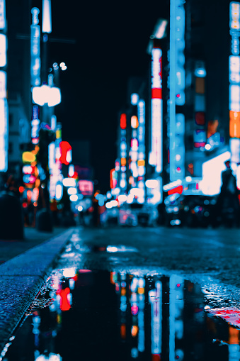 Bright Neon lights reflecting in a puddle on the street in Tokyo, Japan