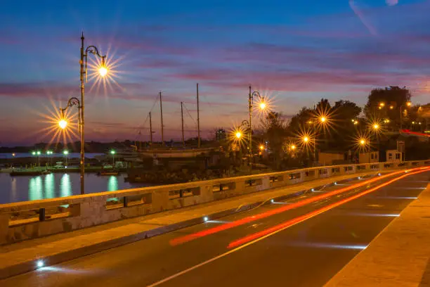 Photo of Colorful sunset and light trails motion of the passing by cars.