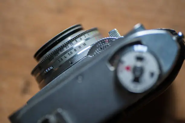 Close up of old 1950s film camera, showing dials and details.  Aperture and shutter speed settings visible on lens.