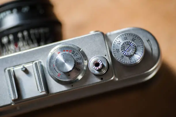 Close up of old 1950s film camera, showing dials and details.  Shutter speed dial, shutter release button and frame counter visible on top plate.