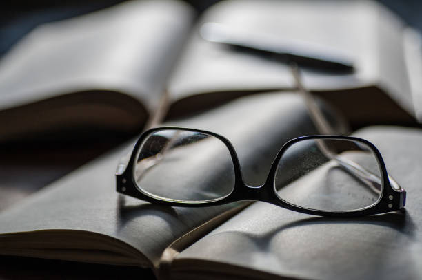 istock Pair of reading glasses and books 1301417388