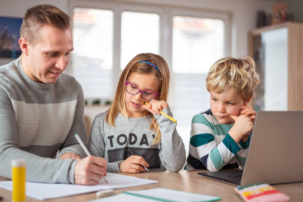 istock Father teaching his two children at home 1301419156