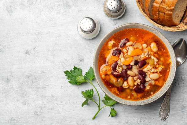 istock Bean soup with bacon, carrot, celery and onion in bowl on concrete background 1301420198