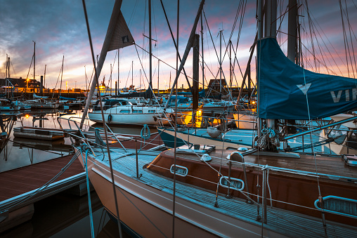 Spiekeroog, Germany - July 8, 2020: Sailboats in the harbor at dusk in a calm summer night. The boats are moored to the jetties of the Spiekerooger Segelclub (SSC).