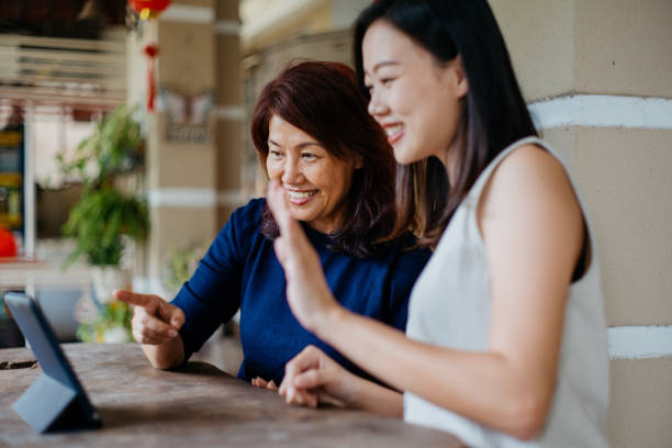 istock Asian mother and daughter using digital tablet for video call 1301422343