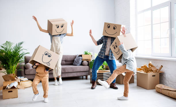 istock Cheerful family in carton boxes having fun during relocation 1301423263