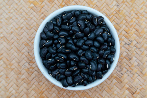 istock Black beans in a white ceramic bowl, placed on a wooden tray. 1301423358