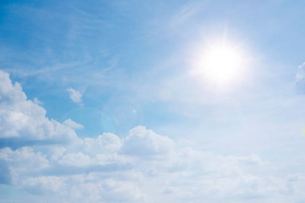 istock blue sky background with white clouds concept. The sun shines in a starry sky 1301423370