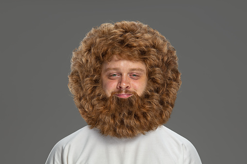 Happiness. Portrait of young handsome very hairy red-hair man, hipster, dude with beard and moustache posing isolated on grey background. Stylish, funny sweet haircut and hairdo. Copy space for ad.