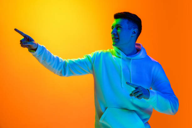 istock Caucasian beautiful man's portrait isolated on yellow studio background in multicolored neon light 1301428126
