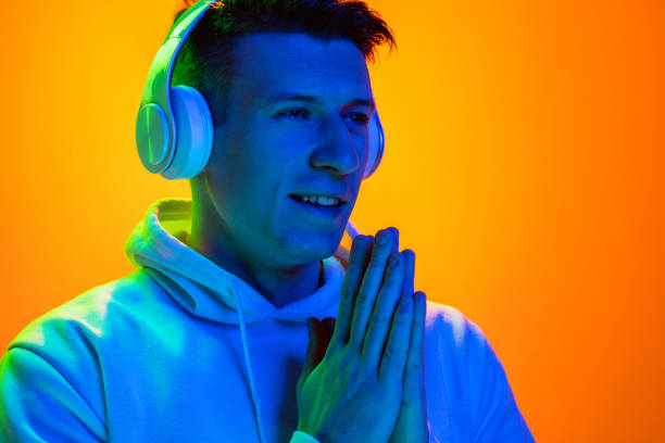 istock Caucasian beautiful man's portrait isolated on yellow studio background in multicolored neon light 1301428135