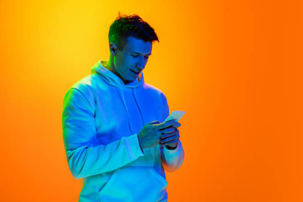 istock Caucasian beautiful man's portrait isolated on yellow studio background in multicolored neon light 1301428144