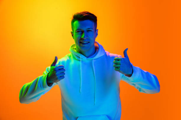 istock Caucasian beautiful man's portrait isolated on yellow studio background in multicolored neon light 1301428148