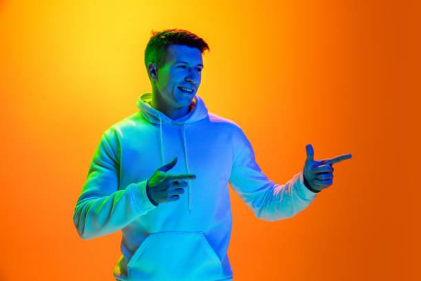 istock Caucasian beautiful man's portrait isolated on yellow studio background in multicolored neon light 1301428163