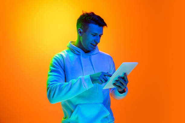 istock Caucasian beautiful man's portrait isolated on yellow studio background in multicolored neon light 1301428164