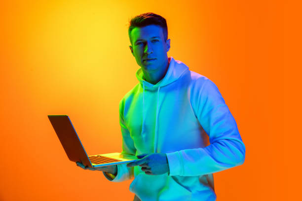 istock Caucasian beautiful man's portrait isolated on yellow studio background in multicolored neon light 1301428210