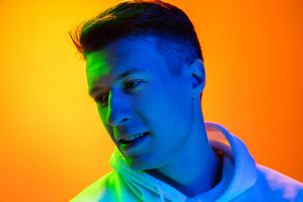 istock Caucasian beautiful man's portrait isolated on yellow studio background in multicolored neon light 1301428227