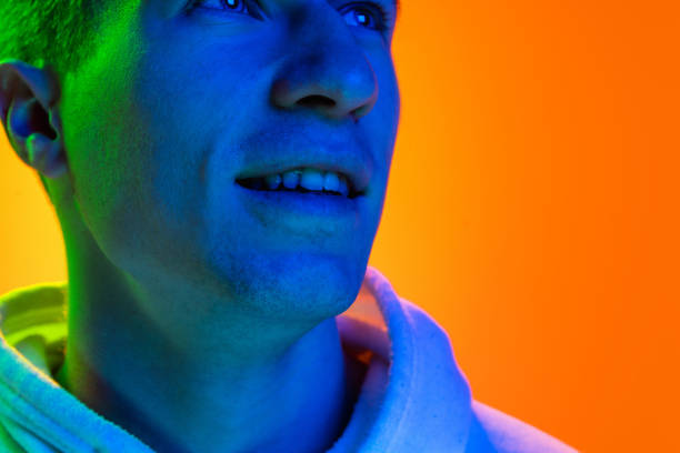 istock Caucasian beautiful man's portrait isolated on yellow studio background in multicolored neon light 1301428685