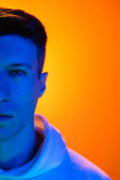 istock Caucasian beautiful man's portrait isolated on yellow studio background in multicolored neon light 1301428695