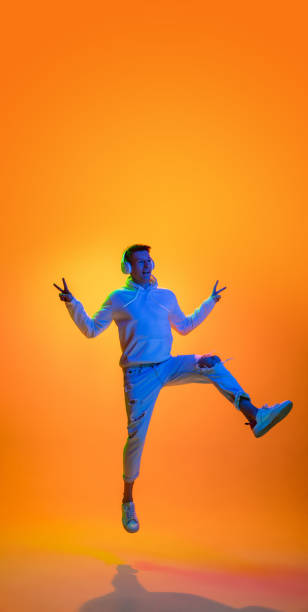 istock Caucasian beautiful man's portrait isolated on yellow studio background in multicolored neon light 1301428697