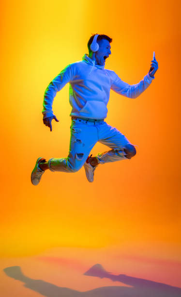 istock Caucasian beautiful man's portrait isolated on yellow studio background in multicolored neon light 1301428705