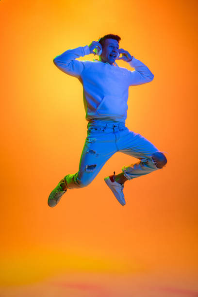 istock Caucasian beautiful man's portrait isolated on yellow studio background in multicolored neon light 1301428710