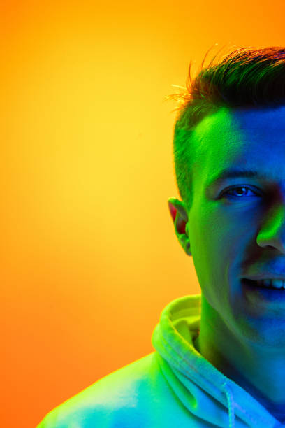 istock Caucasian beautiful man's portrait isolated on yellow studio background in multicolored neon light 1301428727