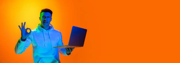 istock Caucasian beautiful man's portrait isolated on yellow studio background in multicolored neon light 1301428740