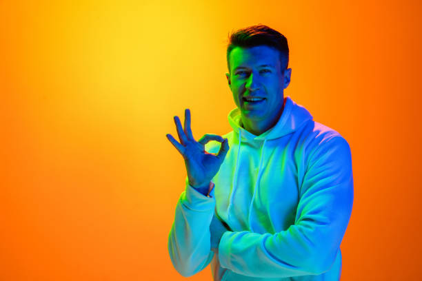istock Caucasian beautiful man's portrait isolated on yellow studio background in multicolored neon light 1301428747