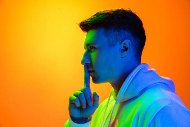 istock Caucasian beautiful man's portrait isolated on yellow studio background in multicolored neon light 1301428759