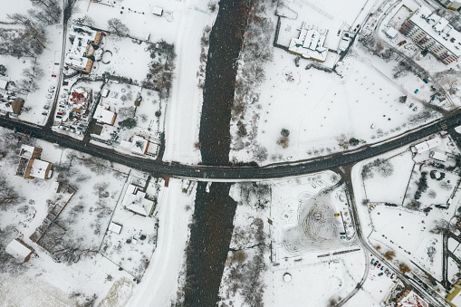 Aerial view of the snowy landscape with a road bridge over the Mała Panew river in Opole - Czarnowasy in winter.
