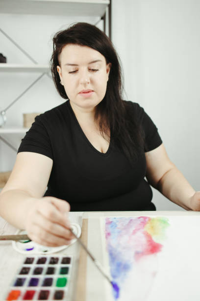 istock Young concentrated woman do watercolor drawing 1301430496