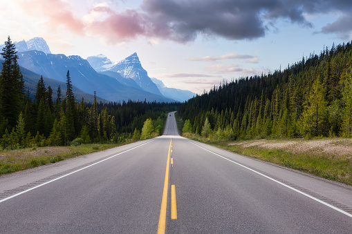 Scenic road in the Canadian Rockies. Colorful Sunset Sky Art Render. Taken in Icefields Parkway, Banff National Park, Alberta, Canada. Panorama Background