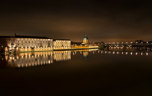 Reflection of Toulouse city over garonne river at night in France, Occitanie, Toulouse