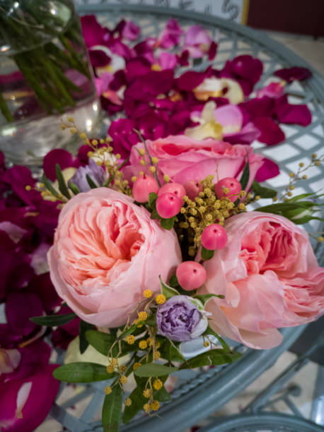 istock Composition from a small bouquet of roses and petals on the table 1301437758