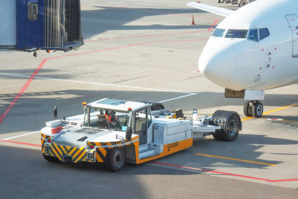 istock Towing a passenger plane using special equipment for aircraft maintenance. Departure flight in the background of the terminal building. 1301439194
