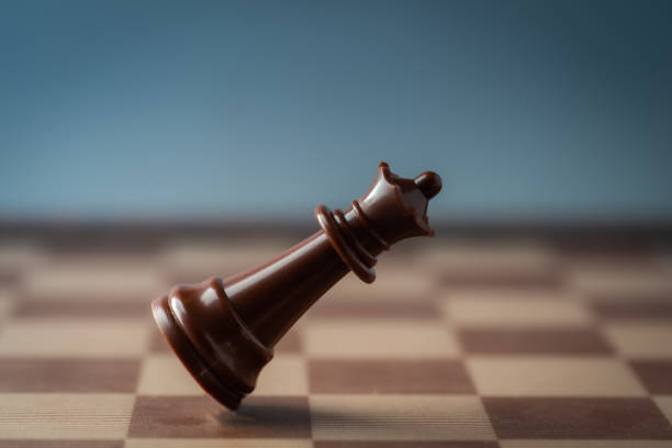 black chess queen falling on chess board concept of failing.