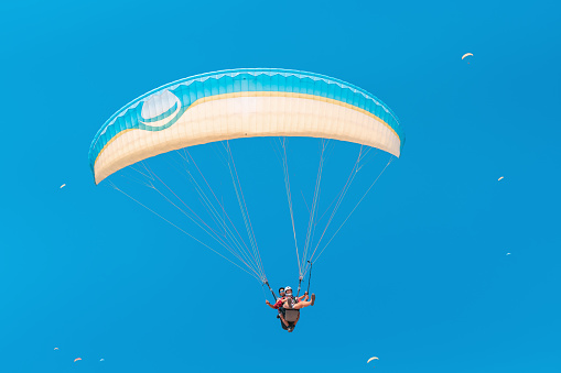 10 September 2020, Oludeniz, Turkey: Paragliders ride tourists and vacationers as entertainment and getting a dose of adrenaline while flying at a great height
