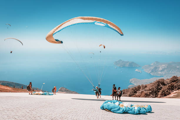 Many paragliding adventurers takeoff in tandem with instructor after a short training session for recreational flight and descent to the sea 09 September 2020, Babadag, Oludeniz, Turkey: Many paragliding adventurers takeoff in tandem with instructor after a short training session for recreational flight and descent to the sea jump jet stock pictures, royalty-free photos & images