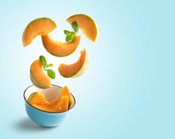 istock Cantaloupe slices flying on blue blue background with copy space 1301440921