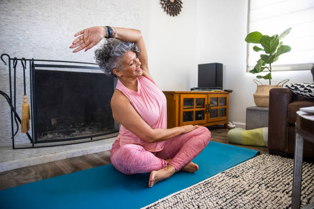 piękna czarna kobieta robi jogę w domu - stretching yoga exercise mat women zdjęcia i obrazy z banku zdjęć