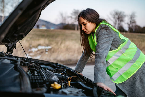 donna che guarda auto rotte motore - vehicle breakdown car stranded women foto e immagini stock