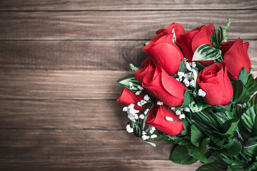 Happy woman gets rose bouquet gift from her boyfriend on Valentines day. Couple love lifestyle concept.