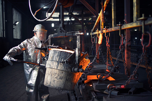 Metal líquido fundido que se vierte en el molde. Trabajador de fundición trabajando con acero caliente. Metalurgia e industria pesada. photo