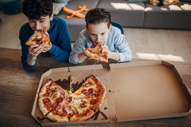istock Two brothers eating pizza together 1301444702