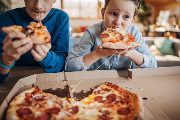 Two brothers eating pizza together