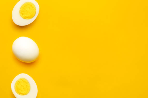 istock Boiled farm chicken eggs on yellow background 1301446205