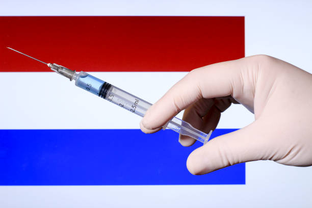 istock Hand holding syringe with covid vaccine 1301446403