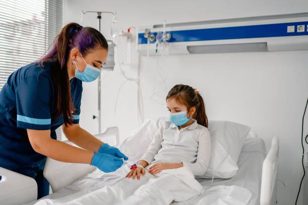 The sick child in the hospital bed , wearing a protective face mask The sick child in the hospital bed , wearing a protective face mask iv drip photos stock pictures, royalty-free photos & images